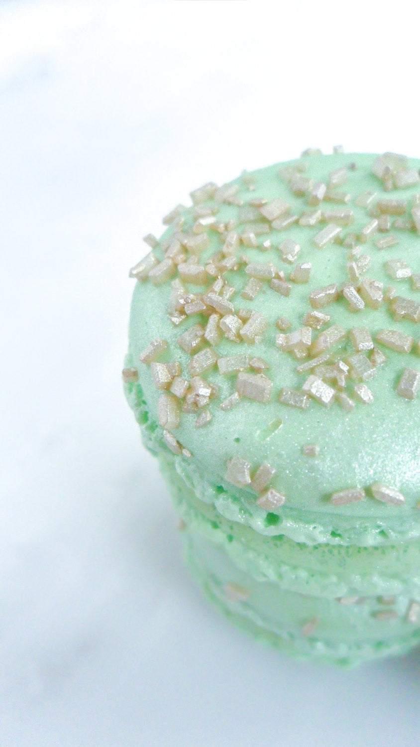 Elegant Mint Green French Macarons Encrusted With Gold Sugar Cyrstals & Madagascar Vanilla Ganache. TheIcedSugarCookie.com Splendid Sweet Shoppe